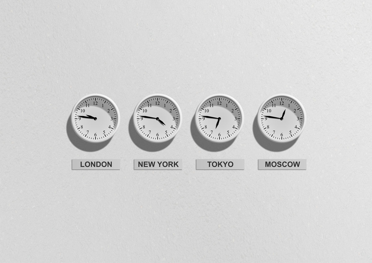 Image of four wall clocks showing different time zones around the world.